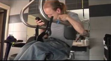 man using SureHands body support to safely get out of his wheelchair independently