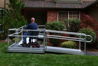 man on scooter enters home via wheelchair ramp installed by Lifeway Mobility