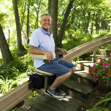 Man riding Bruno Elite Outdoor Stair Lift from Lifeway Mobility MA