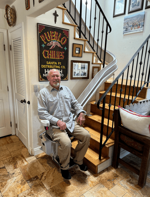 man riding new curved stairlift from Lifeway Mobility - enabling him to remain independent in his home