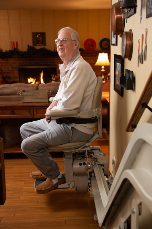 man sitting and smiling on stairlift in Elk Grove home