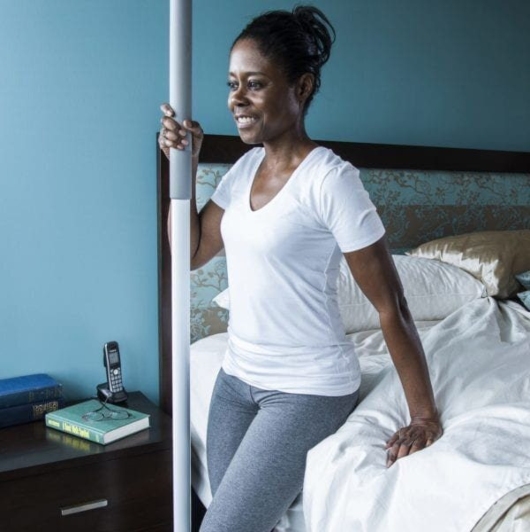 https://www.lifewaymobility.com/Customer-Content/www/products/Categories/Photos/woman-using-safety-pole-from-Lifeway-Mobility-for-support-to-safely-get-out-of-her-bed__1_.jpg